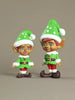Two elf figurines with green hats and outfits on a beige background