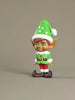Elf figurine with green hat and red pants on a beige background