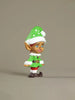 Elf figurine with green outfit and white hat on a beige background