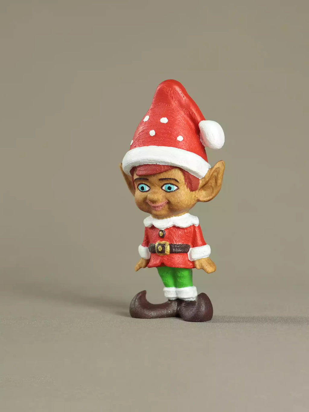 Elf figurine with a red hat on a beige background