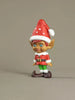 Elf figurine with a red hat on a beige background