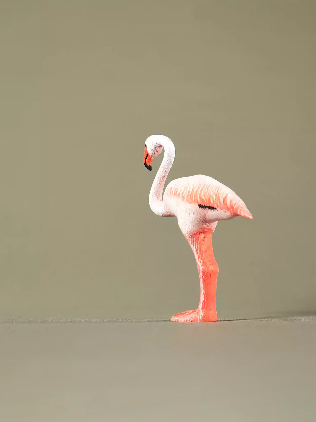Hand-painted wooden flamingo figurine viewed in profile, sustainable eco-friendly toy for open-ended play.