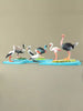Wooden bird toy set arranged on blue puzzle base with handcrafted species like pelican and ostrich.