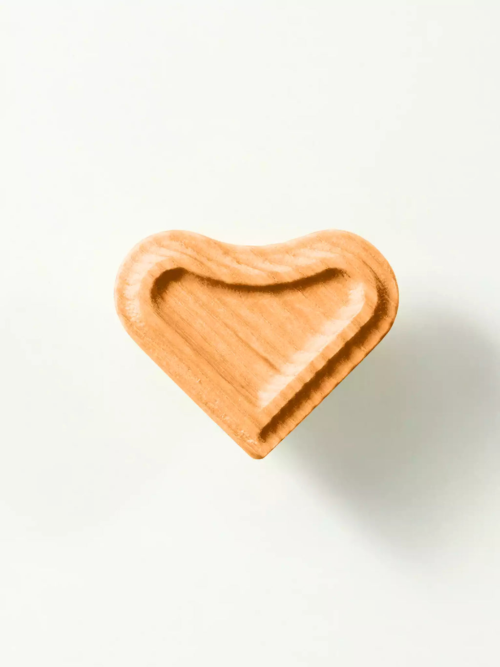 Heart-shaped wooden furniture knob photographed on white background
