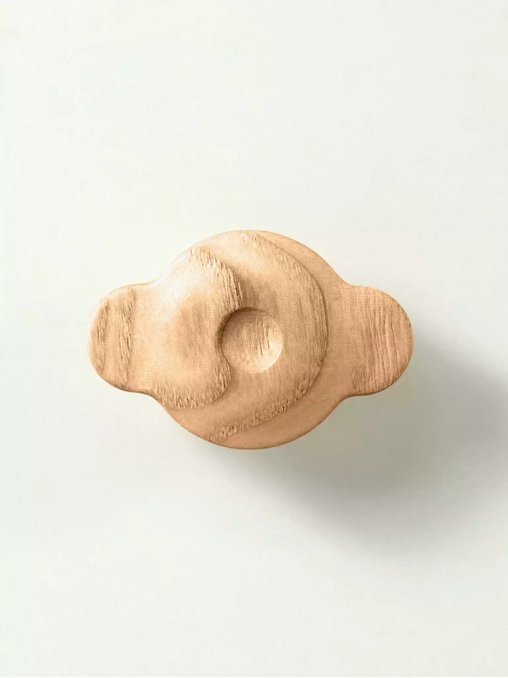 Cloud-shaped wooden drawer handle viewed from above