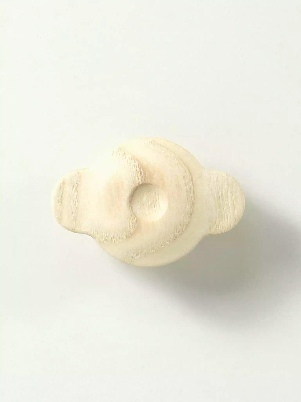 Light cream wooden cabinet handle with smooth rounded edges