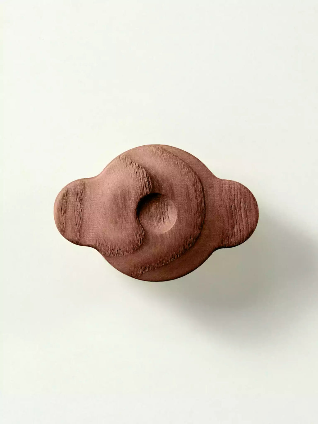 Wooden cabinet handle with soft curves and natural finish