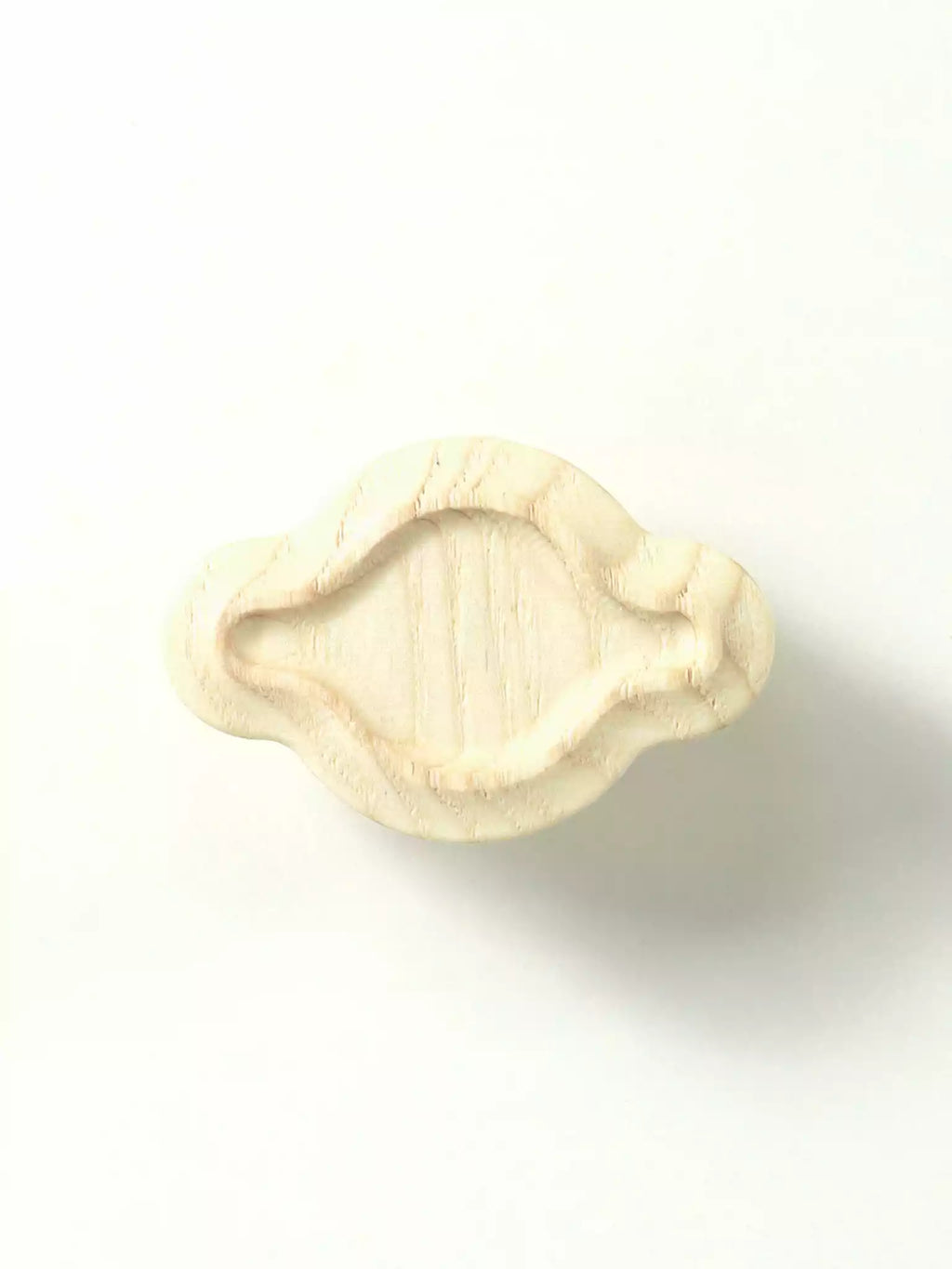 Beige-colored cabinet handle on a white background