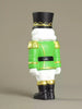 Toy soldier figurine with green uniform and black hat on a beige background