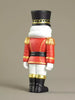 Toy figure of a guard in red uniform with gold accents on a beige background
