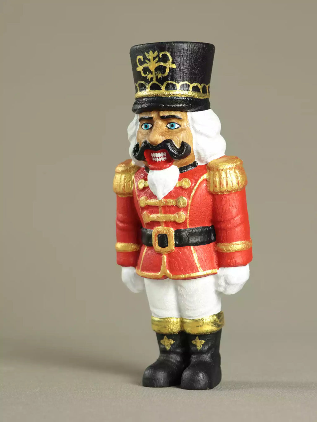 Decorative figurine of a soldier in red uniform with black hat on a beige background