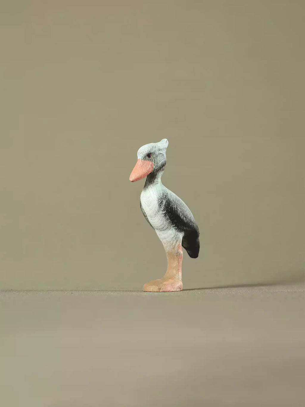 Hand-painted wooden shoebill bird toy on neutral background, eco-friendly Montessori and Waldorf-inspired figure.