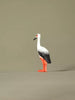 Minimalist product image of a handcrafted stork toy displayed on a plain surface with soft lighting.